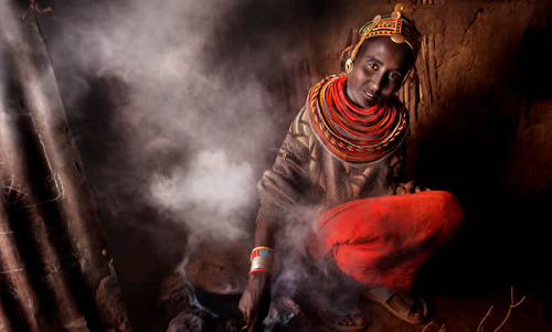 A woman in the Horn of Africa cooks in a smoke-filled room